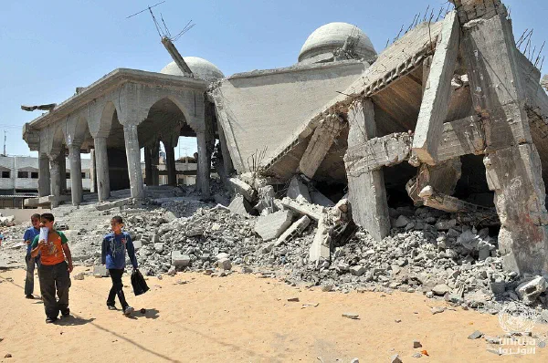 Children walk past a mosque in the Gaza Strip reduced to rubble.