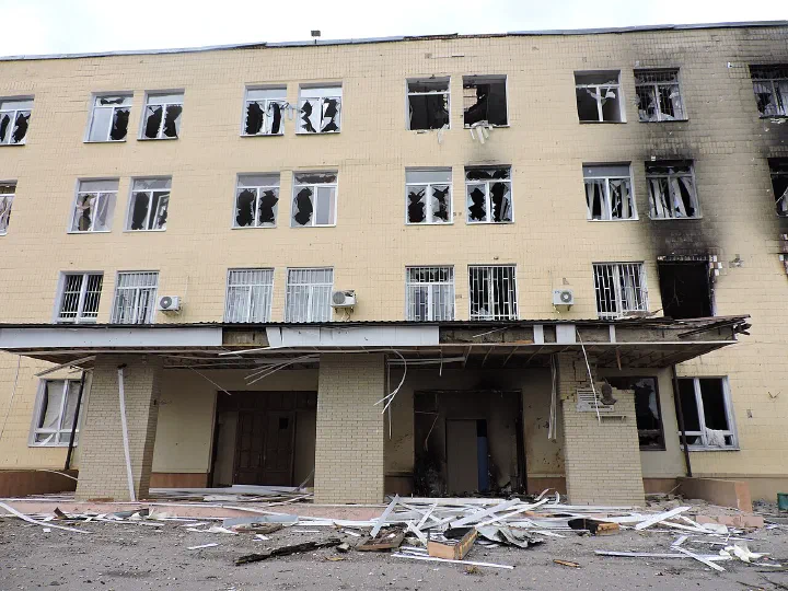 The entrance of Kharkiv University's School of Physics and Technology building, its windows blown out and debris strewn across the ground after Russian shelling.